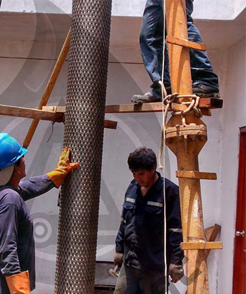 obreros de eperconsac colocando tubo perforador en el suelo